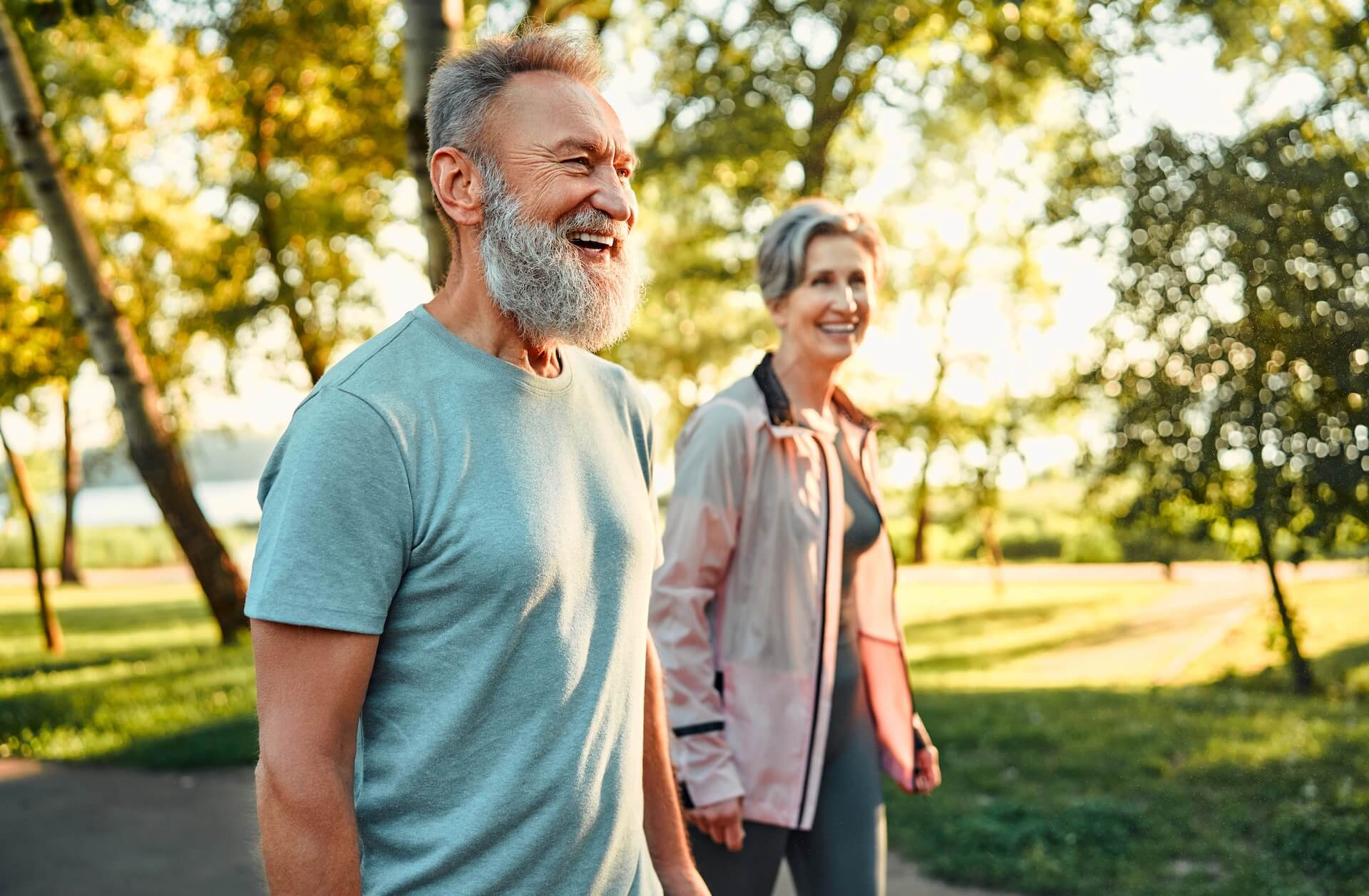 Couple in their 60s walking outdoors, planning for Medicare at 65