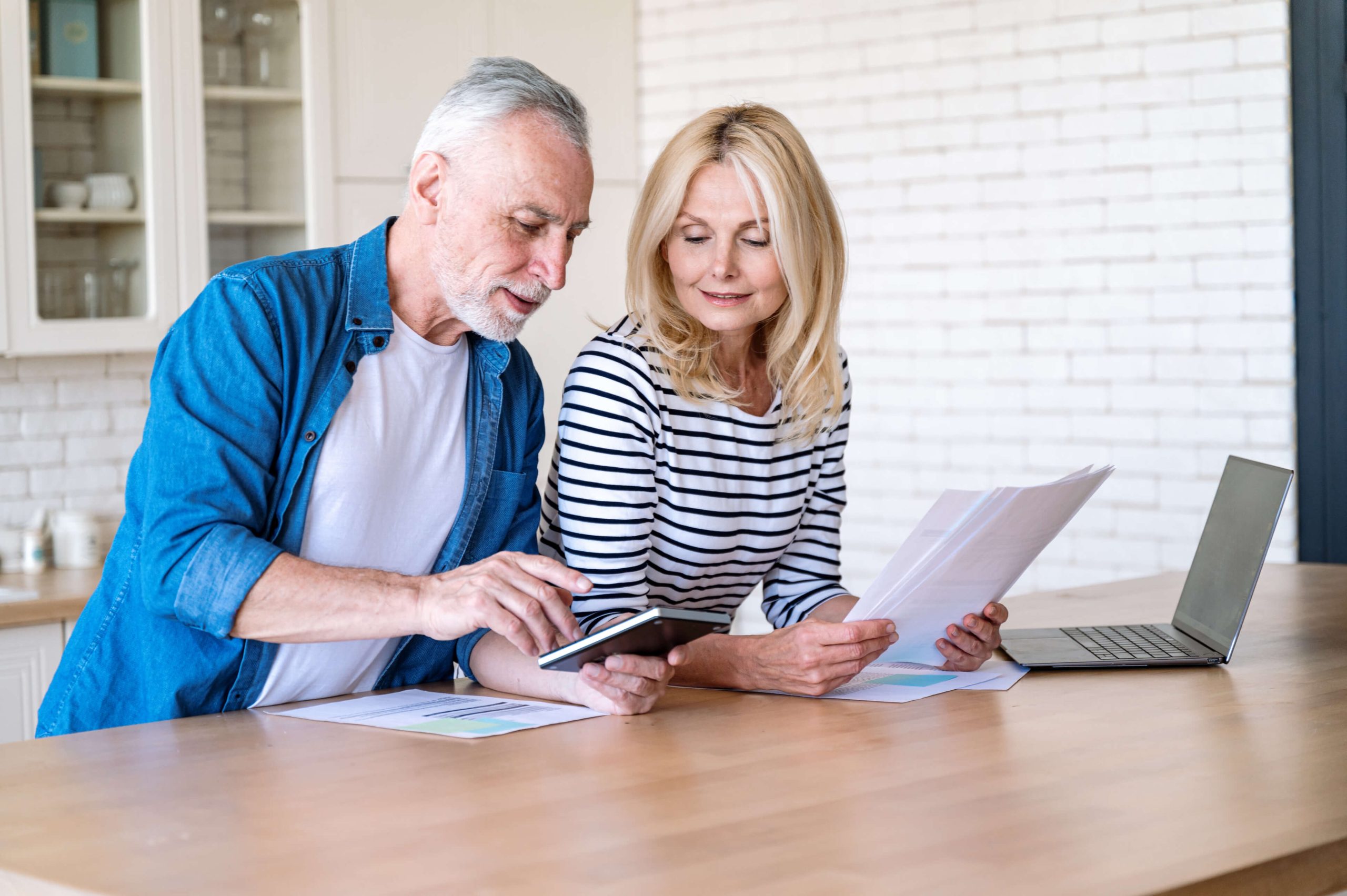 Older couple reviewing their Medicare plan documents at the kitchen table